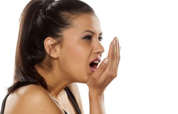 A young woman checking her breath