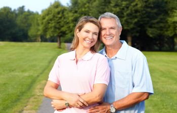 An elderly couple with perfect smiles after implant restoration Marietta GA