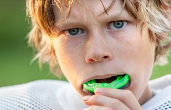 A boy putting mouthguards on his teeth Marietta GA