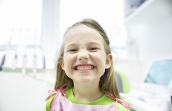 A broadly smiling pre-school girl in a dentist office Marietta GA