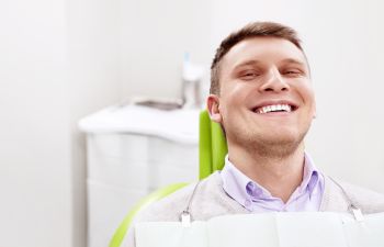 A broadly smiling man in a dentist chair Marietta GA