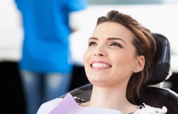 A relaxed woman with beautiful teeth in a dentist chair during cosmetic treatment in Marietta GA.