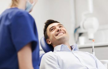 A man in a dentist chair undergoing checkup and cleaning