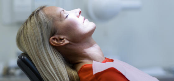 Sedeted mature woman in a dental chair before treatment.